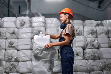 Experienced woman worker in protective uniform working in pesticides production factory, woman is...
