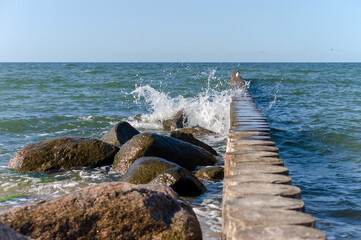 Waves crashing on breakwaters. Sea wave splashing. Waves and a storm at sea. Baltic Sea.