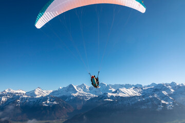 Naklejka na ściany i meble paraglider in the bernese alps.In the background mountain peaks of Eiger, Moench and Jungfrau, Switzerland