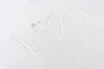 The inscription- I love you,and drawn heart in the snow, top view