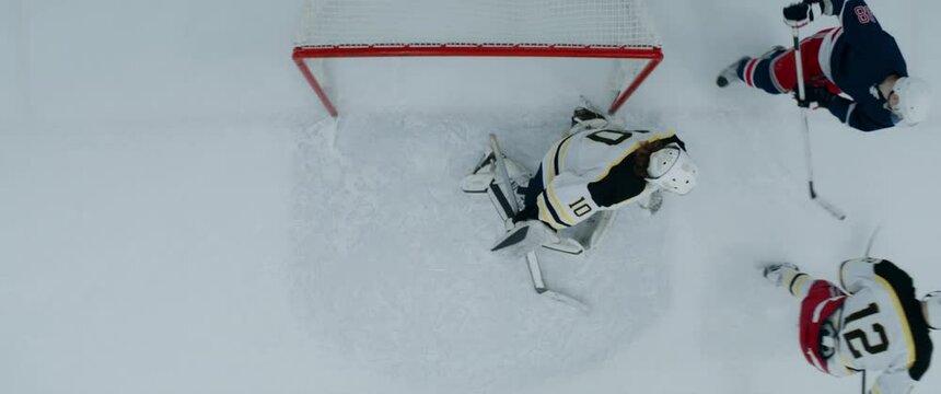 OVERHEAD HIGH ANGLE Goalie makes a save after the shot during the hockey game. Shot with 2x anamorphic lens