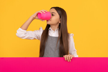 Thirsty girl child drink beverage from plastic cup holding advertising board for copy space, thirst
