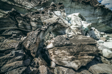 Nature background with icefall near glacier wall with cracks and scratches. Natural backdrop with icy wall and blocks of ice. Beautiful landscape with shiny glacial wall and ice blocks in sunlight.
