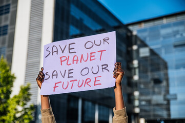 Black person showing poster with inscription save the planet on city street