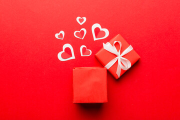 Happy valentines day opened heart shape gift box with small hearts, on colored background, valentines day card - top view concept