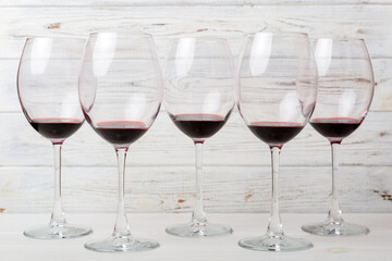 Many glasses of red wine at wine tasting. Concept of red wine on colored background. Top view, flat lay design