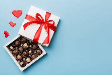 Delicious chocolate pralines in red box for Valentine's Day. Heart shaped box of chocolates top view with copy space