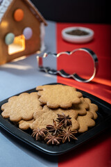 A pile of homemade gingerbread cookies on a plate against the festive background.