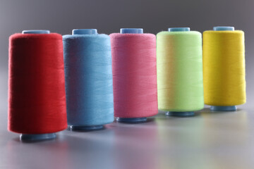 Fabric threads of different colors on gray background