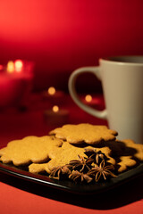 A pile of home made gingerbread cookies on a plate against festive background.
