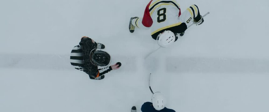 OVERHEAD HIGH ANGLE Shot of a face-off over central circle during a hockey match. Shot with 2x anamorphic lens