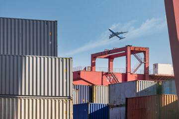 container yard closeup with airplane in sky