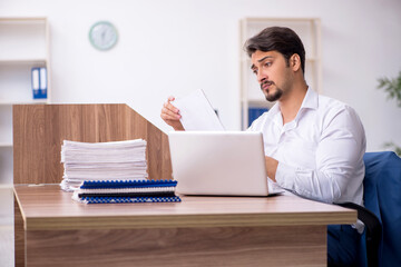 Young male employee and too much work in the office