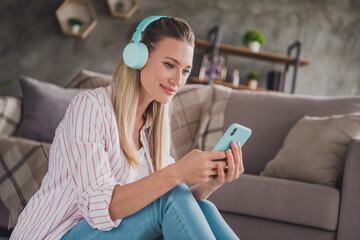 Obraz premium Profile side photo of mature pretty lady look mobile repost choose song melody earphones wireless indoors