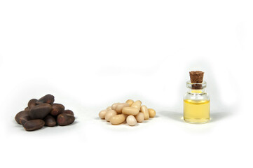 pine nuts in the shell, peeled pine nuts and cedar oil on a white background isolated