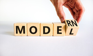 Modern model symbol. Businessman turns a wooden cube and changes the word model to modern....