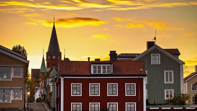 traditional colorful wooden houses in Vastervik, Kalmar, Sweden. Golden cloudscape timelapse on sky
