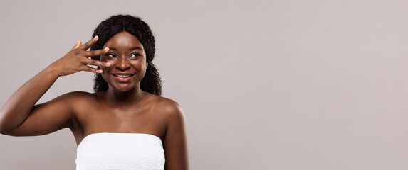 Fototapeta premium Skin Care Steps. Beautiful cheerful african american female holding fingers near face