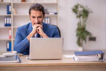 Young male employee sitting in the office