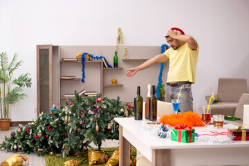 Young man cleaning the apartment after Christmas party