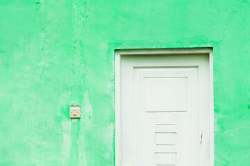 white door and white switch with green walls.