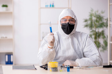 Young male chemist working at the lab during pandemic