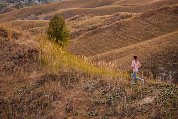 Woman Training, jogging. young sportswoman runs in summer field at sunset. healthy beautiful fit caucasian lady is engaged in fitness, jogging in country in sun. Jogger breathes fresh air on field.