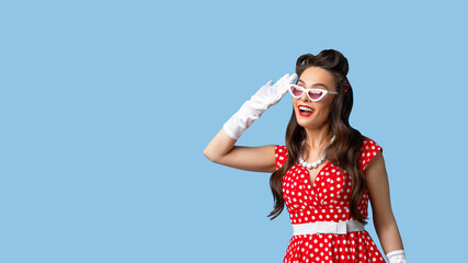 Portrait of curious pinup woman in classic retro dress making hearing gesture, listening carefully...