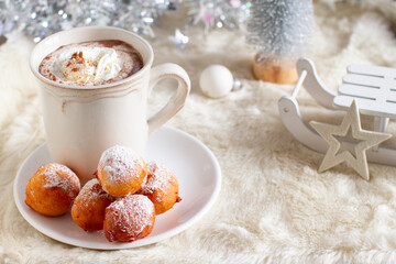 Sweet small donuts with hot chocolate on winter table