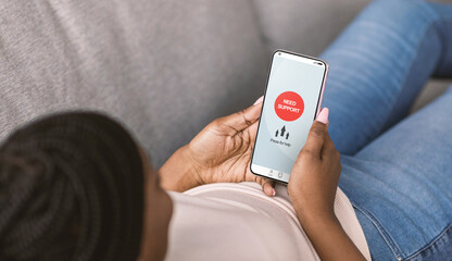 Black woman with smartphone seeking online help with her mental disorder, using mobile app for...