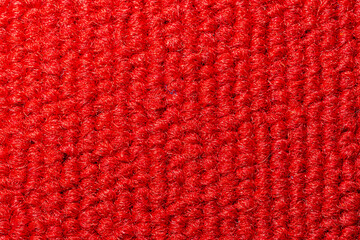 Seamless close up of monochrome red carpet texture background from above.