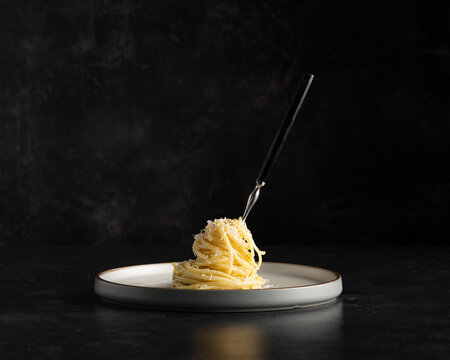 Plated spaghetti wrapped around fork