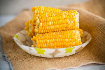 a few heads of boiled corn on a plate