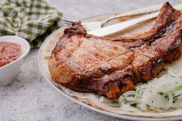 grilled pork loin on a plate with pickled onions