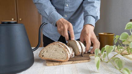 パンを切る男性｜カンパーニュ