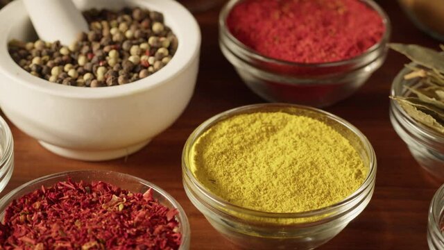 Various spices in glass bowls close-up. Middle eastern and arabian culture. Seasoning and flavors. Pepper, coriander, cinnamon, turmeric, paprika, cumin. Different kinds of dry herbs for cooking. 