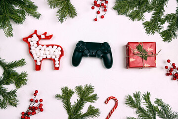 Joystick gaming controller with gift, fir brabches, red berries and marshmallows on white...