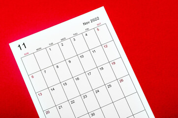 November 2022 calendar sheet on red background.
