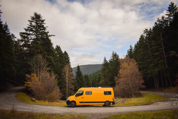 yellow camper van on a curb in the mountains