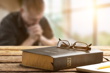 Christian human praying to god with the bible. believe in goodness.