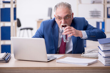 Fototapeta premium Old male employee and too much work in the office