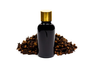 Essential oil of cloves in bottle and pile of dry cloves isolated on white background. 