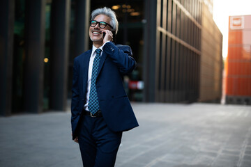 Senior businessman outdoors. Middle-aged businessman talking to the phone