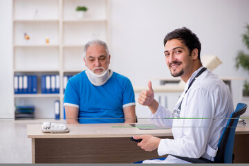 Obraz premium Old neck injured male patient visiting young male doctor