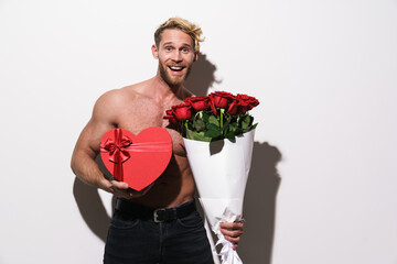 Shirtless blonde man posing with roses and heart gift box