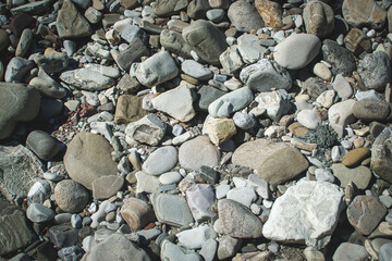 Sea stones background with small pebbles or stone in garden or in the seaside or on a beach. A close up view of rounded smooth polished pebble stones