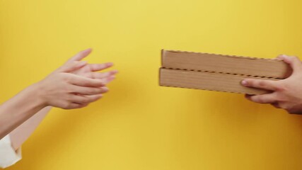 Square cardboard boxes on yellow background. Preparing take away meals. Online contactless food shopping. Food delivery service. Courier giving order, delivering to customer. 