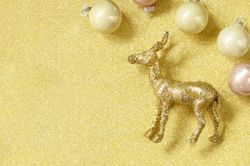 Magic of christmas. Christmas deer gold color palette with decor on a gold background for your greeting card. Top view flat lay. Copy space.