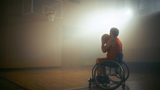 Wheelchair Basketball Player Wearing Red Uniform Shooting Ball Successfully, Scoring a Perfect Goal. Determination, Training, Inspiration of Person with Disability. Dolly Slow Motion with Warm Colors
