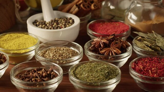 Various spices in glass bowls close-up. Middle eastern and arabian culture. Seasoning and flavors. Pepper, coriander, vanilla, turmeric, paprika, cumin. Different kinds of dry herbs for cooking. 